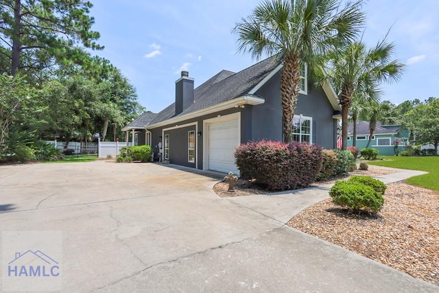 645 Littlefield St, Jesup, GA 31546 - view of side of home featuring a garage, a chimney, driveway, and stucco siding