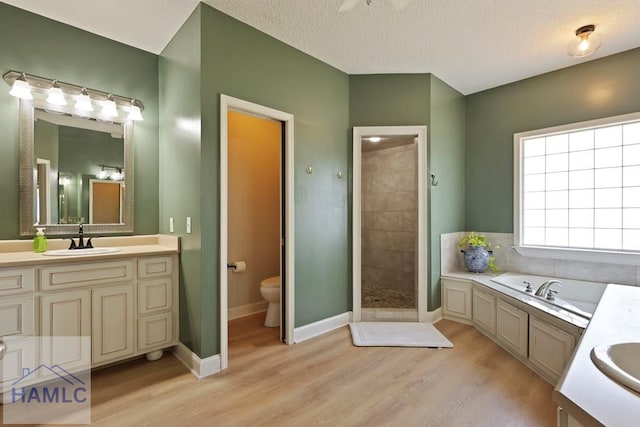 645 Littlefield St, Jesup, GA 31546 - bathroom with wood finished floors, a bath, vanity, tiled shower, and ceiling fan