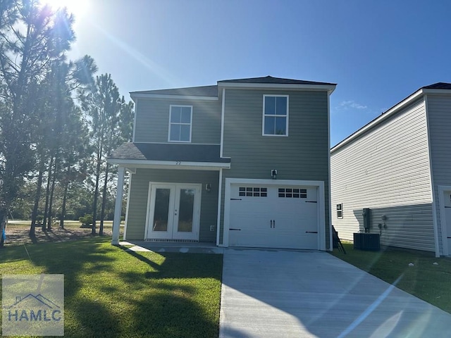 rear view of property with central AC, a garage, a yard, and french doors