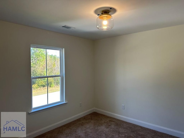 unfurnished room with dark colored carpet