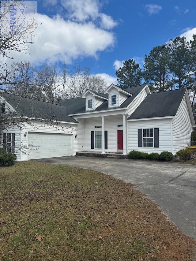 cape cod house featuring a garage, driveway, and a front lawn