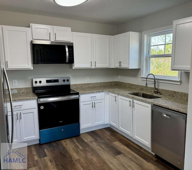 kitchen featuring sink, dark hardwood / wood-style flooring, a textured ceiling, white cabinets, and appliances with stainless steel finishes