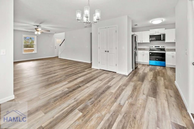 kitchen featuring pendant lighting, white cabinets, ceiling fan with notable chandelier, light hardwood / wood-style flooring, and appliances with stainless steel finishes