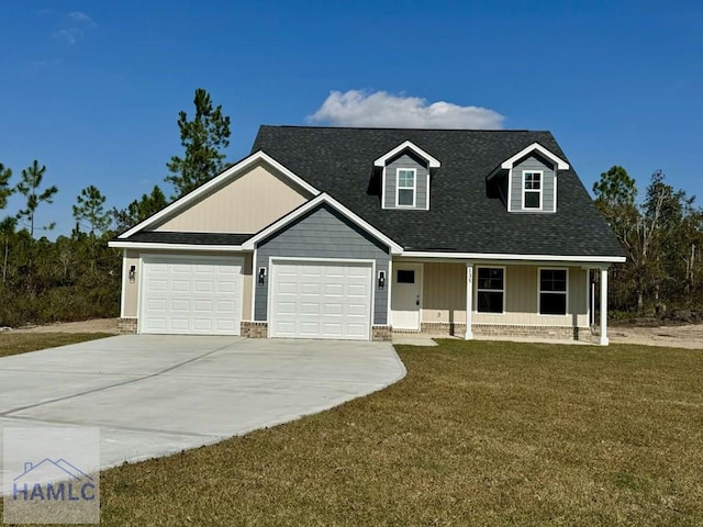 view of front of house featuring a garage, covered porch, and a front yard