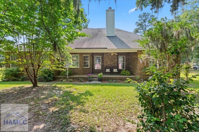 190 Sandpiper Rd, Midway, GA 31320 - view of front facade featuring a front yard, a chimney, brick siding, and a shingled roof
