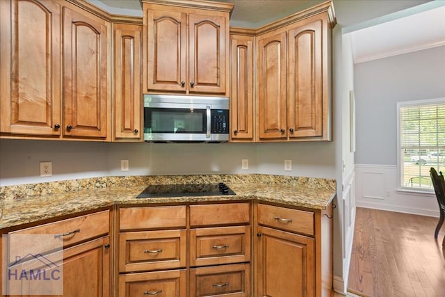190 Sandpiper Rd, Midway, GA 31320 - kitchen featuring stainless steel microwave, wood finished floors, ornamental molding, light stone countertops, and wainscoting
