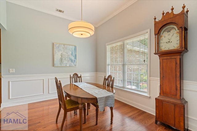 190 Sandpiper Rd, Midway, GA 31320 - dining space with crown molding, a wainscoted wall, wood finished floors, and a decorative wall