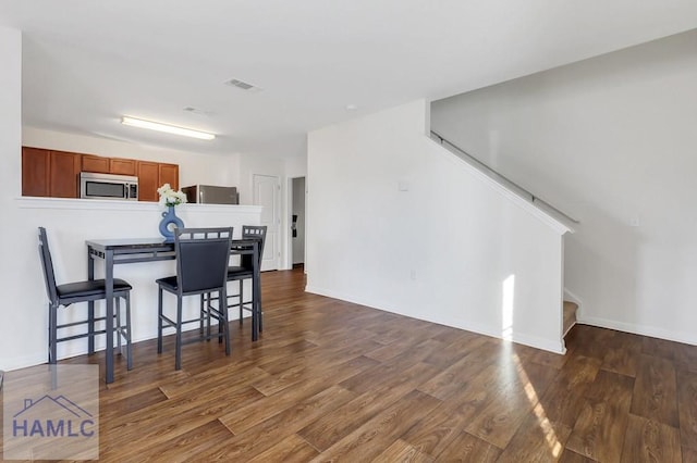 kitchen with dark wood-type flooring and a breakfast bar area