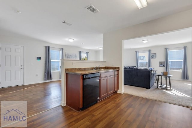 kitchen with dark wood-type flooring, black dishwasher, sink, and kitchen peninsula