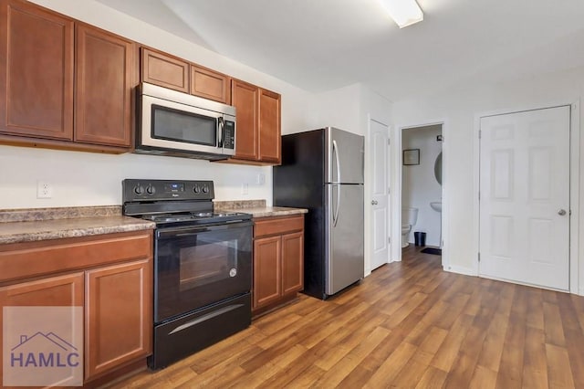 kitchen featuring appliances with stainless steel finishes and light hardwood / wood-style flooring