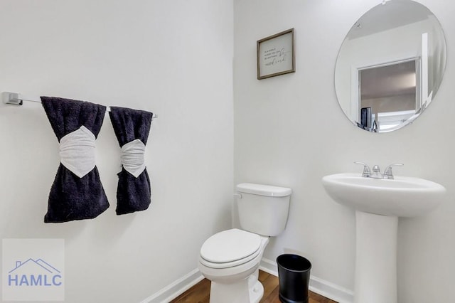 bathroom featuring sink, hardwood / wood-style floors, and toilet