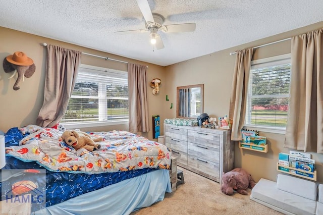 bedroom with light carpet, a textured ceiling, multiple windows, and ceiling fan