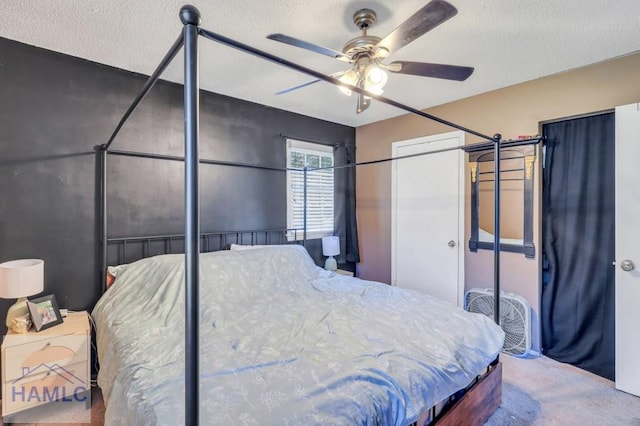 bedroom featuring ceiling fan, carpet floors, and a textured ceiling