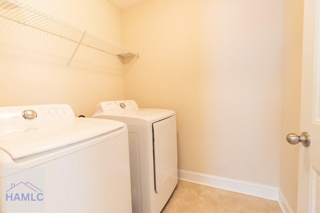 laundry area featuring washer and dryer and light tile patterned floors