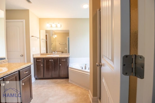 bathroom with a tub to relax in and vanity