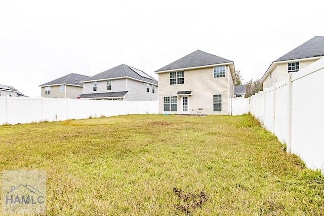 rear view of property featuring a lawn