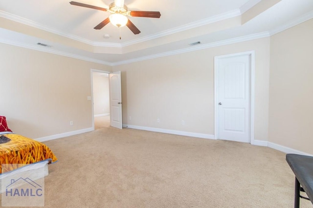 bedroom with ceiling fan, light colored carpet, crown molding, and a tray ceiling