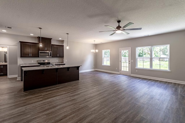 404 Talmadge Rd, Allenhurst, GA 31301 - kitchen with dark wood-type flooring, open floor plan, a ceiling fan, a textured ceiling, and dark brown cabinetry