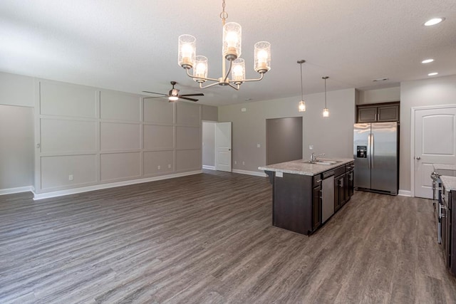404 Talmadge Rd, Allenhurst, GA 31301 - kitchen with ceiling fan, stainless steel appliances, dark brown cabinetry, open floor plan, and a chandelier