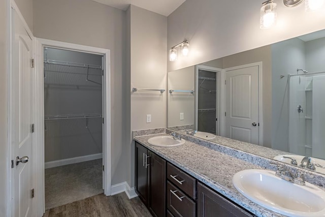 404 Talmadge Rd, Allenhurst, GA 31301 - full bathroom with wood finished floors, double vanity, a walk in closet, and a shower