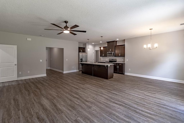 404 Talmadge Rd, Allenhurst, GA 31301 - kitchen with open floor plan, dark wood-style flooring, a chandelier, an island with sink, and dark brown cabinetry