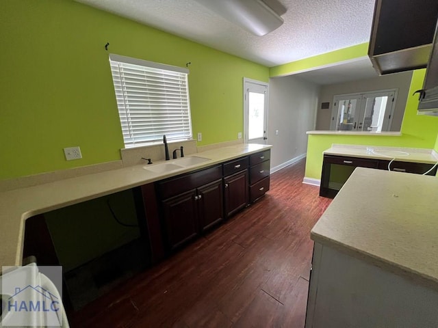 206 Adair St, Jesup, GA 31545 - kitchen with dark wood-style flooring, dark brown cabinets, light countertops, and a textured ceiling