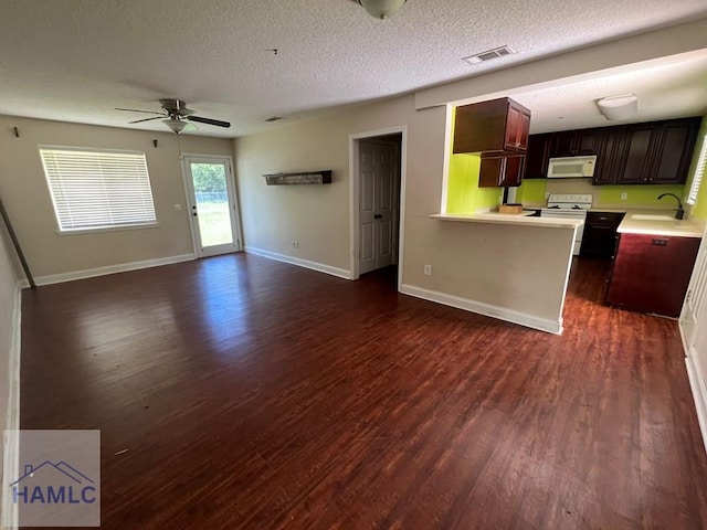 206 Adair St, Jesup, GA 31545 - kitchen featuring white appliances, ceiling fan, light countertops, dark wood-style floors, and a textured ceiling
