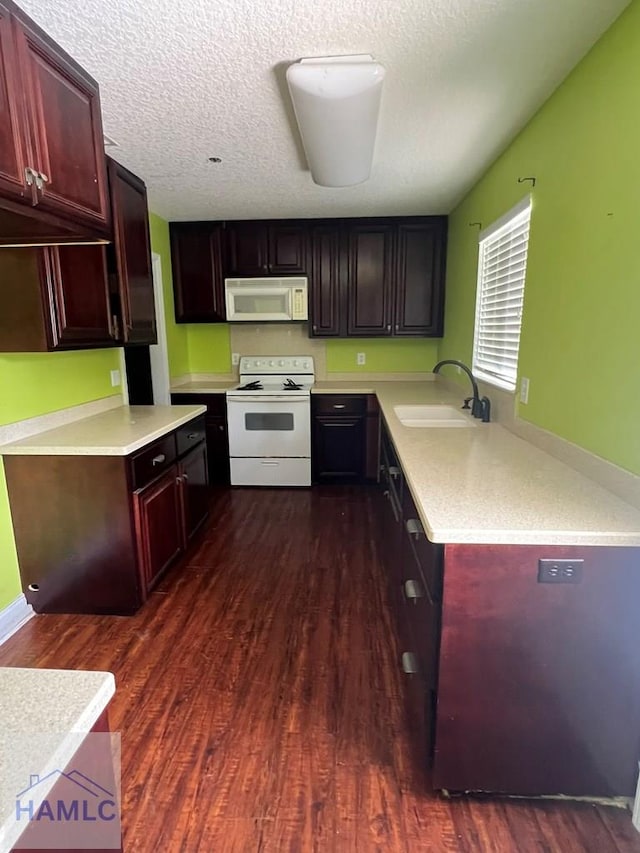 206 Adair St, Jesup, GA 31545 - kitchen featuring white appliances, dark wood-style flooring, light countertops, reddish brown cabinets, and a textured ceiling