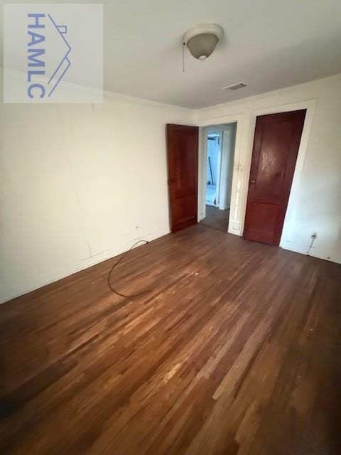unfurnished bedroom with visible vents and dark wood-style floors