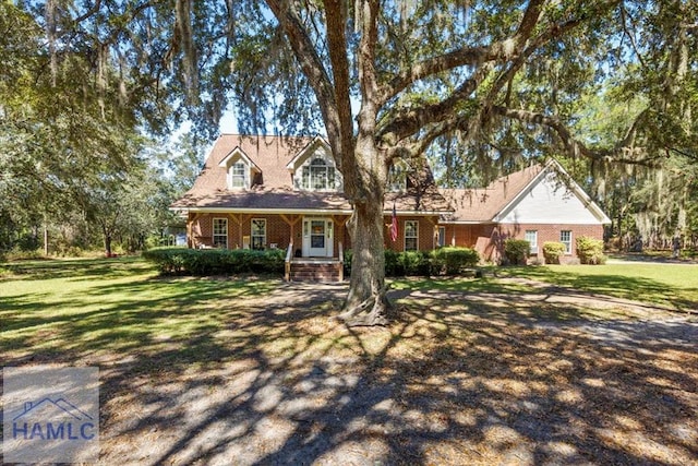 cape cod home featuring a front yard