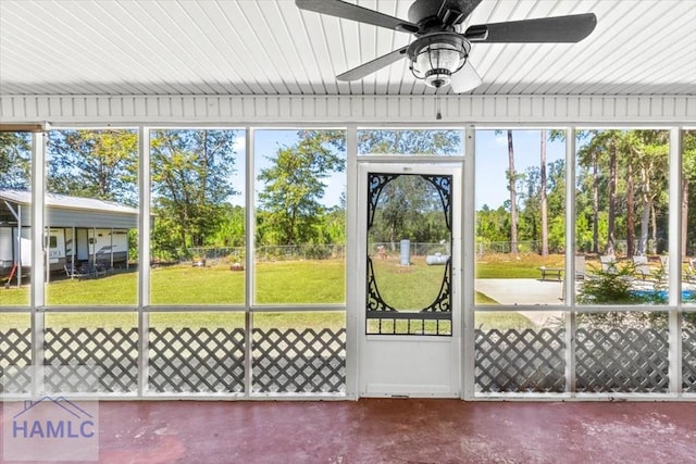 unfurnished sunroom with ceiling fan