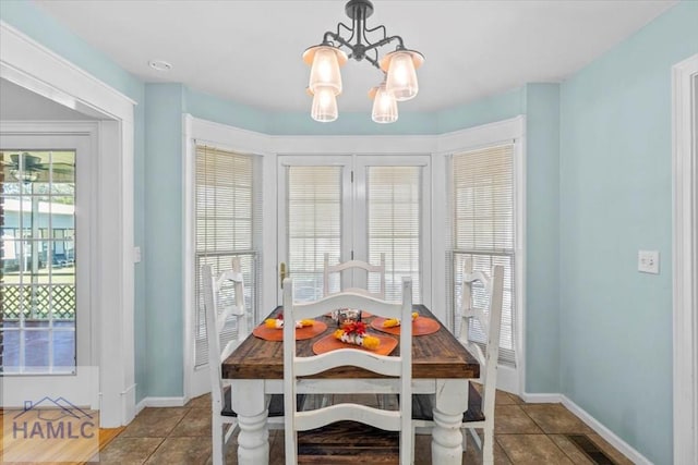 dining space with breakfast area, light tile patterned floors, and an inviting chandelier