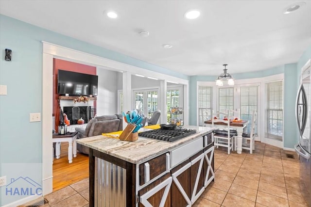 kitchen featuring a chandelier, light tile patterned floors, pendant lighting, and a kitchen island