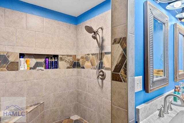 bathroom with tiled shower and sink