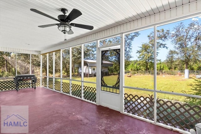 unfurnished sunroom with ceiling fan