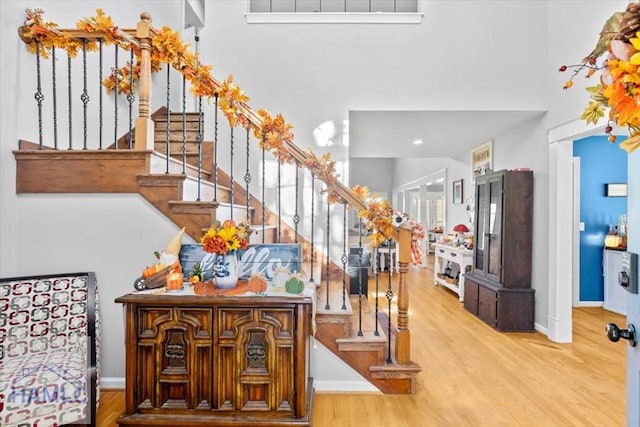 stairs featuring hardwood / wood-style floors and a towering ceiling