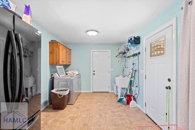 laundry area with separate washer and dryer, sink, light tile patterned floors, and cabinets