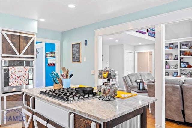 kitchen featuring light stone counters, light hardwood / wood-style floors, and appliances with stainless steel finishes