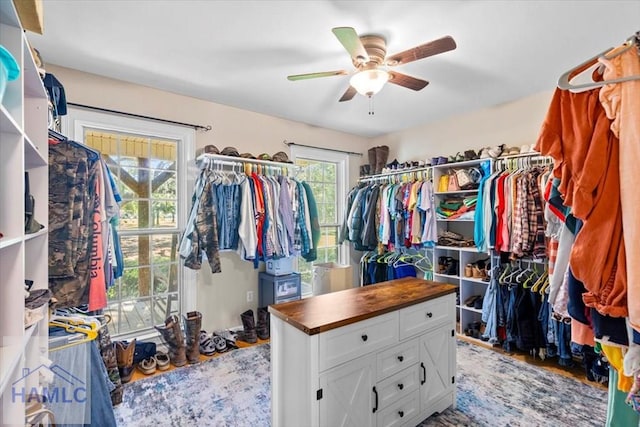 walk in closet with ceiling fan and light hardwood / wood-style floors