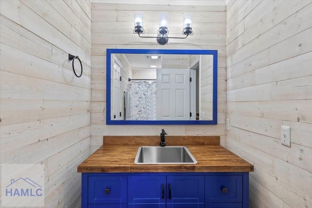 bathroom featuring vanity and wooden walls