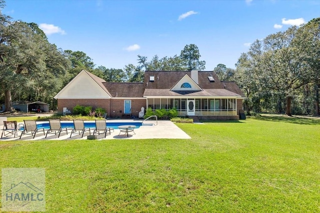 rear view of house featuring a patio area and a yard