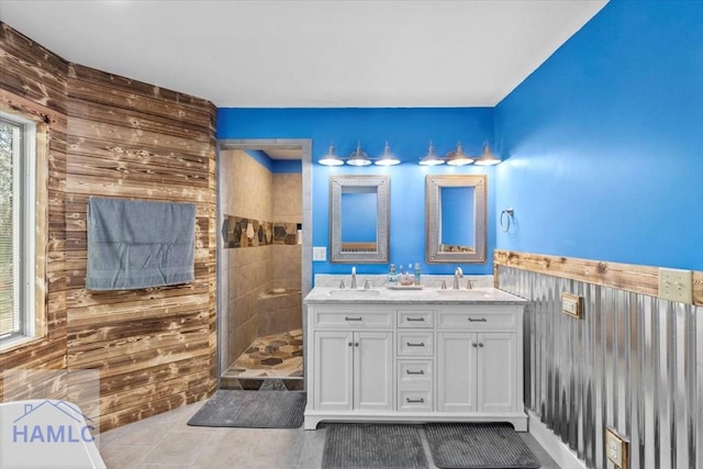 bathroom featuring vanity, tile patterned floors, plenty of natural light, and wooden walls