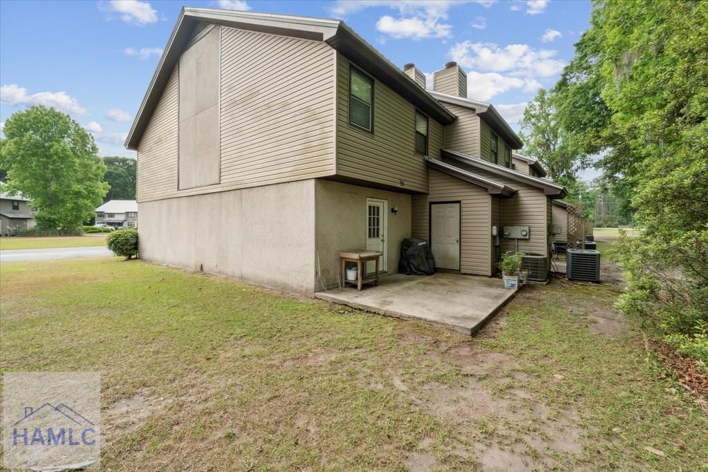 601 Tupelo Trl Unit 39I, Hinesville, GA 31313 - rear view of house featuring a lawn, a patio, a chimney, and central air condition unit