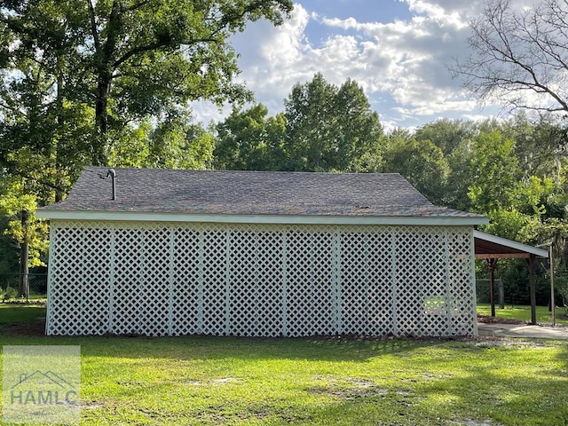 view of outbuilding with a lawn and a carport