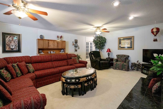 living room featuring ornamental molding, carpet flooring, a textured ceiling, and ceiling fan