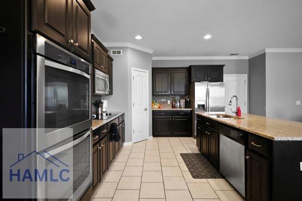 246 Cumberland Dr NE, Ludowici, GA 31316 - kitchen featuring stainless steel appliances, crown molding, light tile patterned floors, recessed lighting, and a kitchen island with sink