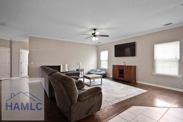 246 Cumberland Dr NE, Ludowici, GA 31316 - living room featuring a ceiling fan, ornamental molding, and tile patterned flooring