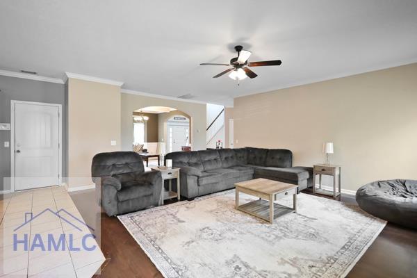 246 Cumberland Dr NE, Ludowici, GA 31316 - living area with arched walkways, ceiling fan, and crown molding