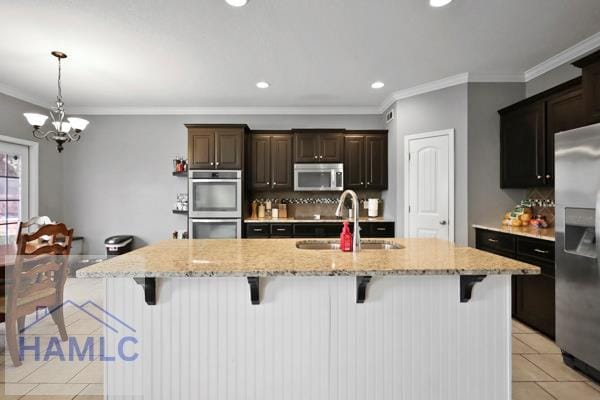 246 Cumberland Dr NE, Ludowici, GA 31316 - kitchen with stainless steel appliances, light tile patterned floors, ornamental molding, a chandelier, and a breakfast bar