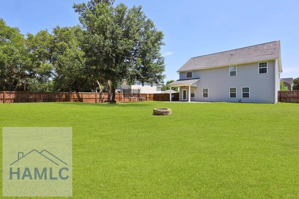 246 Cumberland Dr NE, Ludowici, GA 31316 - fenced backyard with an outdoor fire pit